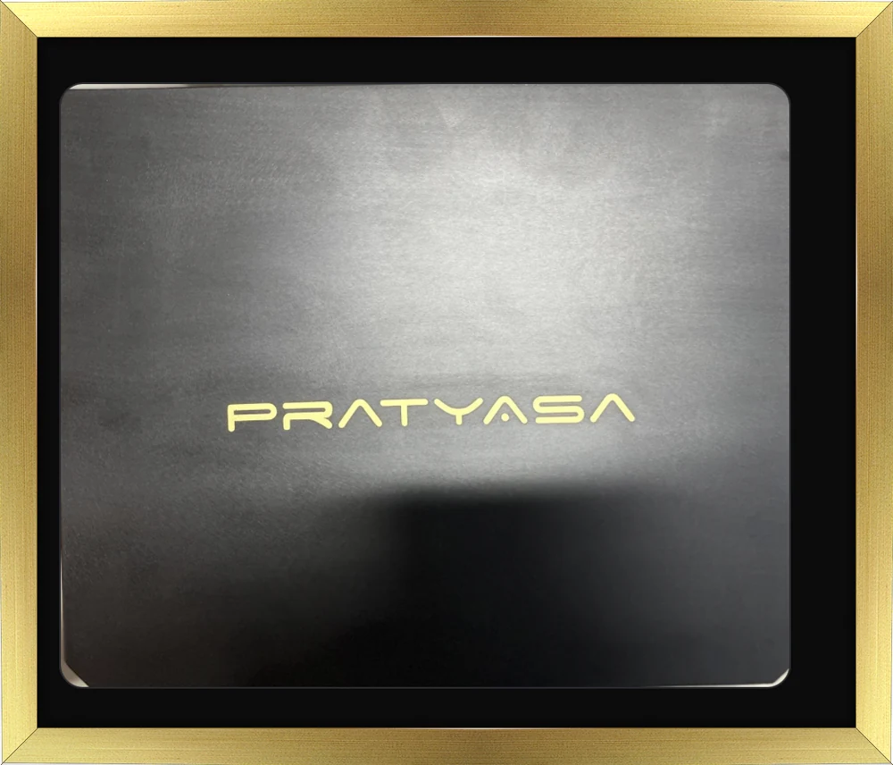 The Pratyasa presentation case, matte black with the name embossed in gold, in a gold frame.